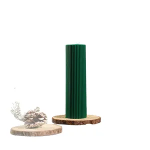 Dark green ribbed cylindrical soy scented wax candle for Christmas home decor and gifts.