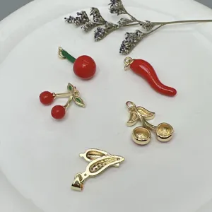 Vista detallada de dijes colgantes de cereza y chile esmaltados DIY para collares y pulseras.