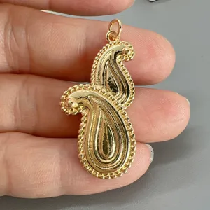 Detailaufnahme des goldenen Paisley-Metallanhängers mit Perlenkante, ideal für DIY-Schmuck.