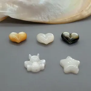 Detailansicht von Perlmuttperlen mit Herz-, Bienen- und Sternmotiven für DIY-Schmuck.
