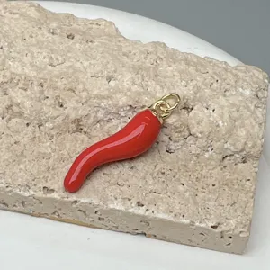 Colgante de chile rojo primer plano, anillo de oro, detalle esmalte gota aceite DIY.