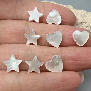 Vue detaillee perles nacre etoile et coeur, accessoires de bijoux DIY en coquillage naturel.
