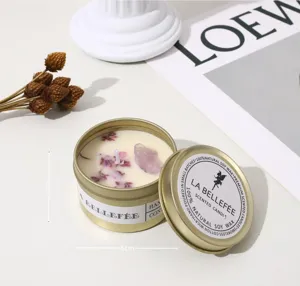 Gold scented candle in round tin with dried flowers and crystal, diameter 6cm, height 4cm.