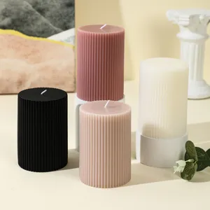 Detail view of ribbed cylindrical scented soy candles in assorted colors for home decor.