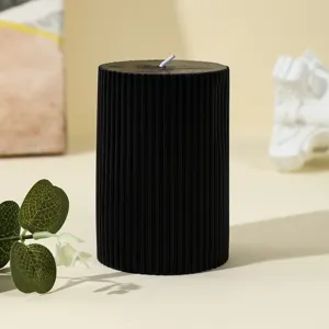 Close-up view of a black fluted pillar scented candle with textured design for home decor.