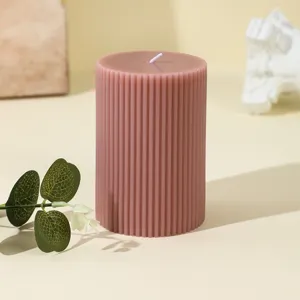 Detailed view of a pink ribbed pillar scented soy candle, perfect for cozy home decor and aesthetics.