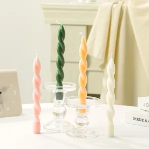 Nahaufnahme von bunten Spiral-Drehkerzen mit klaren Glashaltern für gemütliche Deko.