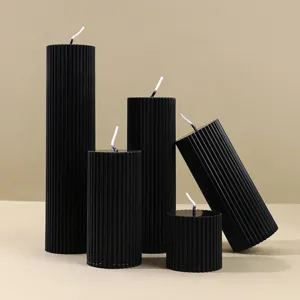 Detalle de velas perfumadas negras acanaladas con diseño clásico de columna romana para decoración.