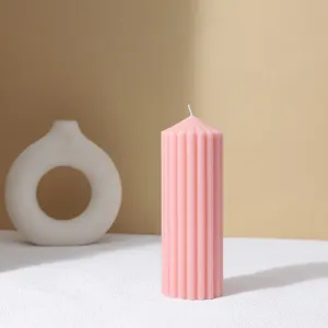 Pink striped pillar scented candle, minimalist home decor detail shot for cozy room ambiance.