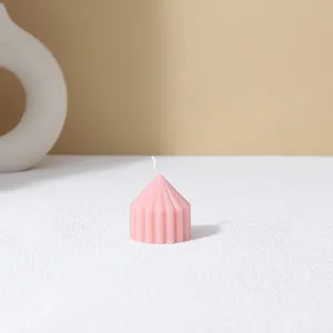 Pink striped pointed pillar scented candle detail showing minimalist home decor aesthetic.
