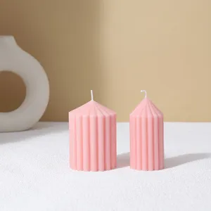 Pink striped pillar scented candle, minimalist home decor detail for cozy room ambiance.