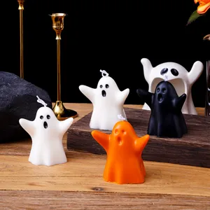Vue détaillée de bougies parfumées fantômes d'Halloween mignonnes en blanc, noir et orange.