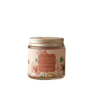 Glass jar scented candle with floral label, jasmine and pink pepper fragrance for home decor.