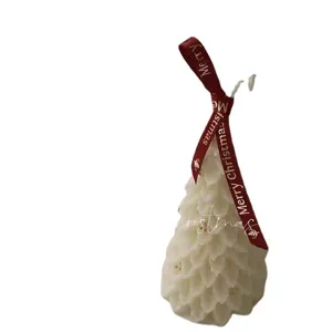Handcrafted Christmas tree scented candle with pinecone texture and festive red ribbon decor.