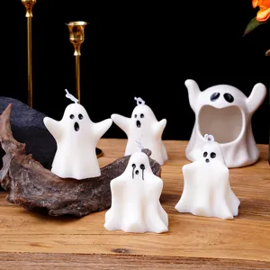 Vue détaillée de bougies fantômes blanches mignonnes avec des visages effrayants sur table bois.