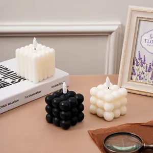 Vista detallada de velas electrónicas creativas de burbuja y pilar en una mesa de madera.