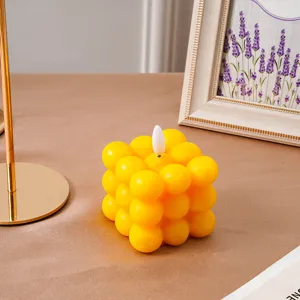 Vela electrónica de cubo burbuja amarilla con detalle de llama para decoración de fiesta y hogar.