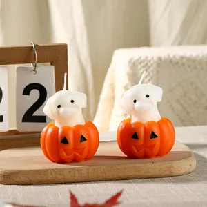 Nahaufnahme von Halloween Welpe und Kürbis Duftkerzen, perfekte festliche Heimdeko.