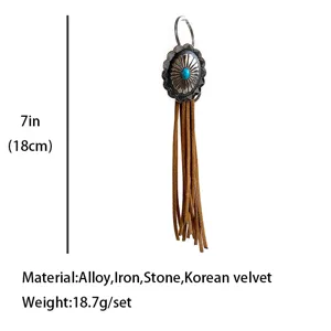 Vintage western style tassel keychain with turquoise concho and leather fringe details.