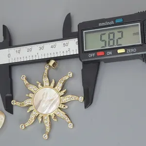 Detailed view of vintage sun pendant with mother of pearl and cubic zirconia, measured 58.2mm.