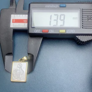 Dettaglio in primo piano del pendente religioso in madreperla misurato con calibro 13.9mm