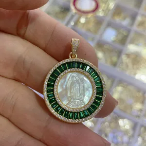 Vintage round mother-of-pearl portrait pendant detail with green crystal and sparkling gems.