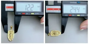 Vista dettagliata del ciondolo a scudo dorato che mostra misurazioni precise con un calibro.
