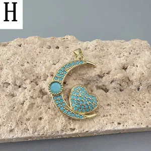 Vergoldeter Mond und Herz Anhänger mit Türkis Steinen Detailansicht der Handwerkskunst.