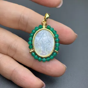 Detailed view of religious Virgin Mary pendant with mother of pearl and green agate beads.