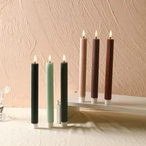 Gros plan de bougies coniques LED colorées et striées avec effet de flamme réaliste pour déco.