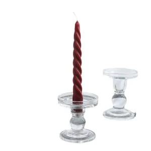 Transparenter Kerzenhalter aus Glas mit roter spiralförmiger Stabkerze für Tischdeko.