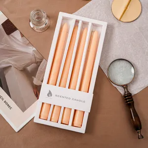 Detailansicht langer Duftkerzen im weißen Karton mit elegantem warmen Orangeton.
