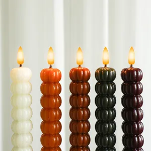 Vue détaillée des bougies piliers citrouille, design empilé coloré avec flamme LED.
