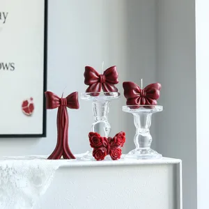 Bougie parfumée en cire de soja nœud bordeaux pour décoration intérieure et ambiance de fête.