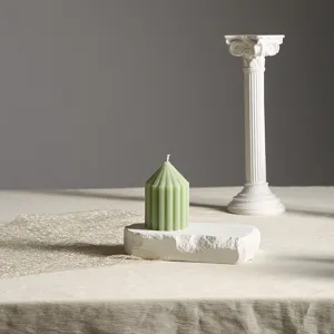 Detaillierte Nahaufnahme der mintgrünen gerippten Stumpenkerze mit weißer römischer Säule.