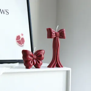 Bougie parfumée en cire de soja nœud bourgogne pour décoration intérieure et fête.