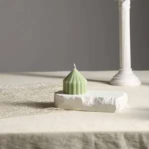 Mintgrüne Duftkerze Detailaufnahme, geometrische Säulenwachs für gemütliche Raumdekoration.