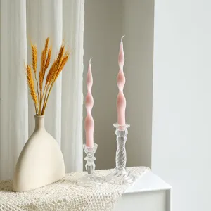 Detail view of pink twisted scented soy wax pillar candles with clear glass candle holders.