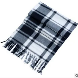 Detailed view of a classic black white grey plaid winter scarf with cozy fringe design.