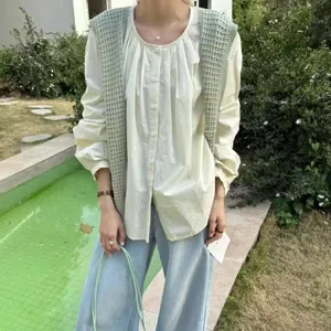 Detail view of the elegant knitted hollow shawl paired with casual blouse and denim jeans.