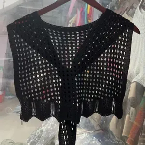 Detailed view of a black knitted hollow shawl, open-work mesh design, stylish summer accessory.