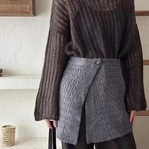 Grey cable knit wrap skirt detail, stylish buttoned waist accessory for women fashion outfit.