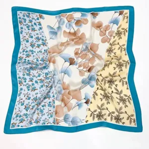 Exquisite multi-pattern silk scarf detail featuring retro floral and leaf prints with blue border.