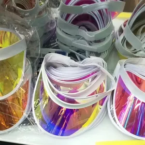 Dettaglio visiera parasole in PVC olografico riflettente colorato, cappello vuoto regolabile.