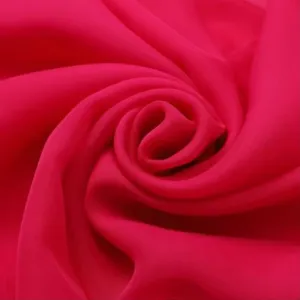 Closeup of hot pink imitation silk chiffon fabric draped in a lovely swirl pattern.