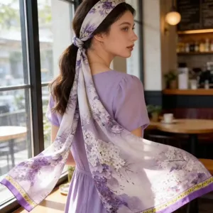 Detailed view of women's purple floral silk scarf, elegant long hair ribbon and shawl design.