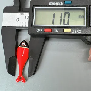 Nahaufnahme eines roten Emaillierte Fisch Anhängers mit Größenmessung, Schmuckzubehör.