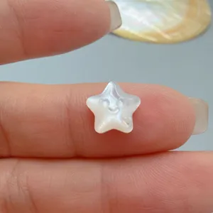 Detailaufnahme einer süßen Stern geschnitzten weißen Perlmuttperle, ideal für DIY Schmuck.