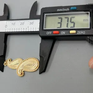 Detailaufnahme eines goldenen tropfenformigen Anhängers mit digitalem Messschieber.