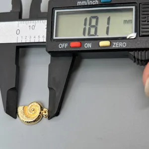 Goldener Ammoniten-Muschel-Anhänger Detailaufnahme, zeigt präzise Größenmessung mit Messschieber.